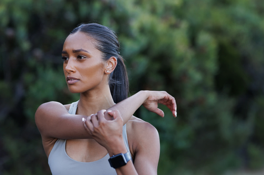 solo female runner stopped to stretch